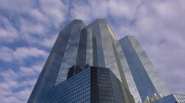 Bulutlar bir iş bölgesindeki aynalı cam gökdelene yansıyor. Şirket işi, yüksek gökdelen cam yüzeyi. Zaman aşımı. Yüksek kalite 4k görüntü