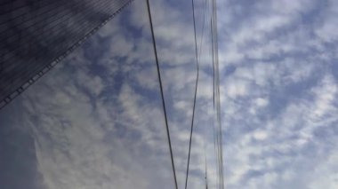 Cam gökdelenler mavi gökyüzünü bulutlarla yansıtıyor. Modern bir iş bölgesinde kamera hareketi. Başarılı iş konsepti. Yüksek kalite 4k görüntü