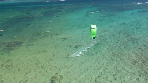一名身穿白色泳衣的运动员用绿松石和温水在绿色风筝上耕耘印度洋 水花从冲浪板下飞溅而出 好棒的运动假期的概念 — 图库视频影像