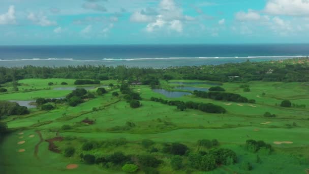 海の美しい島で緑のゴルフコースのドローンビュー 海沿いのゴルフクラブ 裕福な人々のためのスポーツ 高品質4K映像 — ストック動画