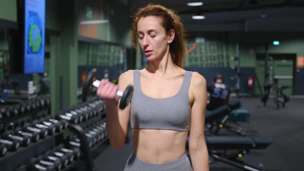女性の体の筋肉のためのダンベルとスポーツ演習 ジムで運動する女性 高品質4K映像 — ストック動画