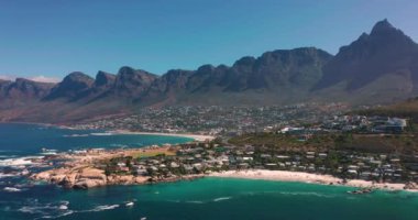 Coastal large city with a harbor on the ocean. Industrial and logistics facilities in the center of the city. Drone view of a growing city in South Africa. High quality 4k footage