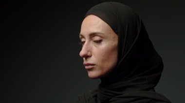 Face with natural make up of attractive muslim girl wearing traditional hijab scarf. Her brown eyes looking at camera, islam concept extreme close up 4k footage. High quality 4k footage