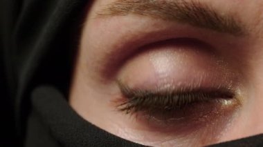 Face with natural make up of attractive muslim girl wearing traditional hijab scarf. Her brown eyes looking at camera, islam concept extreme close up 4k footage. High quality 4k footage