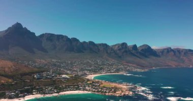 Coastal large city with a harbor on the ocean. Industrial and logistics facilities in the center of the city. Drone view of a growing city in South Africa. High quality 4k footage