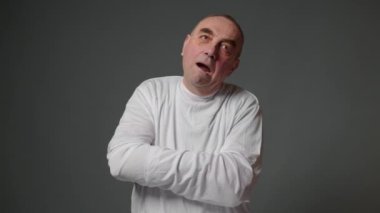 Elderly mad male patient in straitjacket is going crazy in a mental hospital. Mentally ill old man with psychic disorders and bipolar disease. Concept of paranoia or schizophrenia and madness.