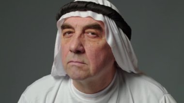 Elderly man with united arab emirates traditional clothes posing in a studio. Beautiful islamic portrait of portrait arab businessman kandur. Studio footage with different poses. High quality 4k