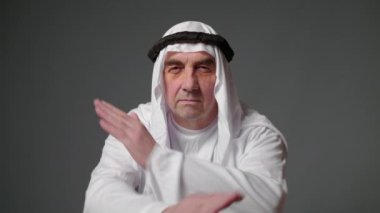 Elderly man with united arab emirates traditional clothes posing in a studio. Beautiful islamic portrait of portrait arab businessman kandur. Studio footage with different poses. High quality 4k