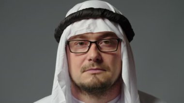 Young muslim sheikh is shocked and surprised. A man in surprise shoots glasses and looks at the camera in surprise. High quality 4k footage