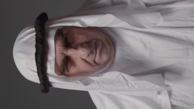 Man with united arab emirates traditional clothes posing in a studio. Beautiful islamic portrait of portrait arab businessman kandur. Studio footage with different poses. High quality 4k footage