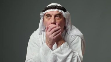 Elderly man with united arab emirates traditional clothes posing in a studio. Beautiful islamic portrait of portrait arab businessman kandur. Studio footage with different poses. High quality 4k