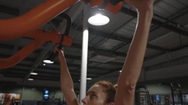 Vücut geliştiren kadın spor salonunda barfiks egzersizi yapıyor. Güzel, güçlü atletik kadınlar sırt kaslarını şişiriyor spor yapıyor ve vücut geliştirme konsepti geliştiriyor. Yüksek kalite 4k görüntü