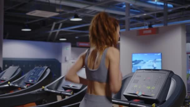 Rear View Girl Long Hair Headphones Runs Treadmill Modern Gym — Video Stock