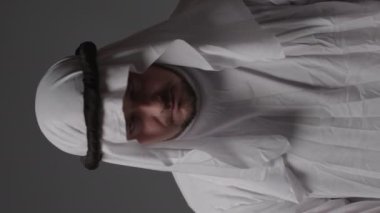 Man with united arab emirates traditional clothes posing in a studio. Beautiful islamic portrait of portrait arab businessman kandur. Studio footage with different poses. High quality 4k footage