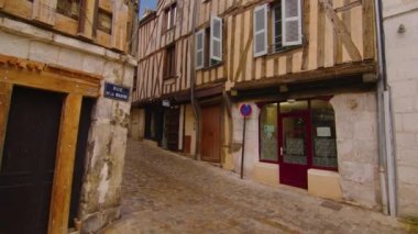 View of a beautiful street with old traditional French houses in the center of Auxerre with clouds in the background. Legacy of French history. Historic hotels, colorful houses in France. Time Lapse.