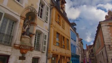 View of a beautiful street with old traditional French houses in the center of Auxerre with clouds in the background. Legacy of French history. Historic hotels, colorful houses in France. Time Lapse.