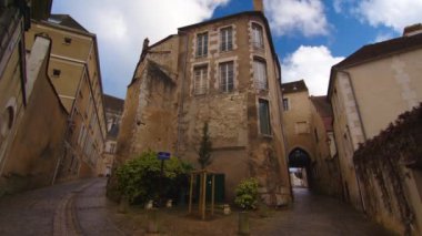 View of a beautiful street with old traditional French houses in the center of Auxerre with clouds in the background. Legacy of French history. Historic hotels, colorful houses in France. Time Lapse.