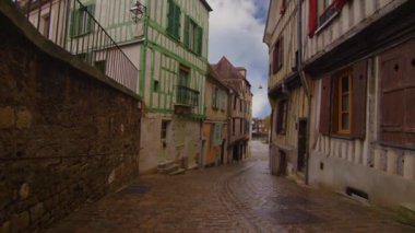 Auxerre 'in merkezinde, arkasında bulutlar olan eski geleneksel Fransız evlerinin olduğu güzel bir cadde manzarası. Fransız tarihinin mirası. Tarihi oteller, Fransa 'da renkli evler. Zaman Süreleri.