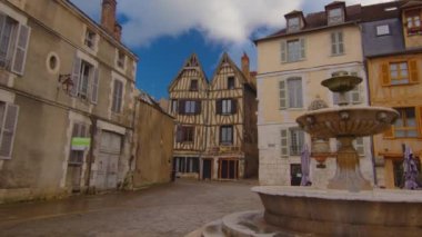 View of a beautiful street with old traditional French houses in the center of Auxerre with clouds in the background. Legacy of French history. Historic hotels, colorful houses in France. Time Lapse.