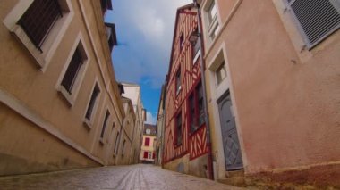 View of a beautiful street with old traditional French houses in the center of Auxerre with clouds in the background. Legacy of French history. Historic hotels, colorful houses in France. Time Lapse.