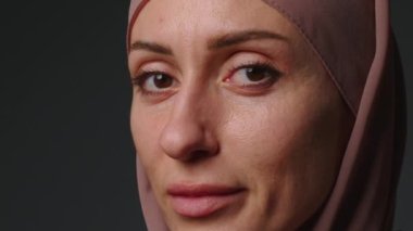 Close up portrait of independent muslim business woman looking serious confident at camera wearing traditional headscarf. Portrait muslim woman in hijab with bright makeup watching smiling.