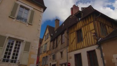 View of a beautiful street with old traditional French houses in the center of Auxerre with clouds in the background. Legacy of French history. Historic hotels, colorful houses in France. Time Lapse.