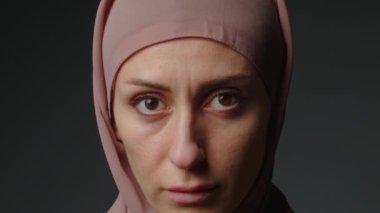Geleneksel başörtüsü takan bağımsız Müslüman iş kadınının kamera karşısında kendine güveni tam portresi. Tesettürlü, parlak makyajlı, gülümseyen Müslüman kadın portresi..