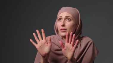 Aggressive male partner bullies his wife. Poor girl covers her face with her hands. Man hit her face. Family aggression of men over muslim woman wife. Fist menace to a woman. High quality 4k footage