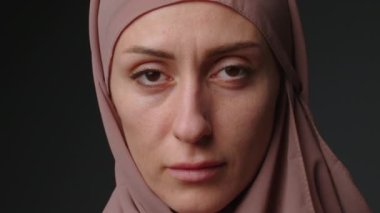 Geleneksel başörtüsü takan bağımsız Müslüman iş kadınının kamera karşısında kendine güveni tam portresi. Tesettürlü, parlak makyajlı, gülümseyen Müslüman kadın portresi..