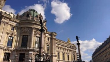 View of The Paris Opera facade. Street with walking people and moving cars in front of it, cloudy weather. High quality 4k footage