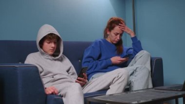 Anne ve oğlu birbirleriyle konuşmadan kanepede oturuyorlar. Cihazlara bağımlı, cep telefonu kullanan bir aile, evde birbirini görmezden gelen bir laptop. İnternet saplantısı. Yüksek kalite 4k görüntü