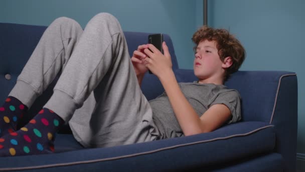 Nastolatek Siedzi Kanapie Bez Słowa Chłopak Uzależniony Gadżetów Używający Telefonu — Wideo stockowe