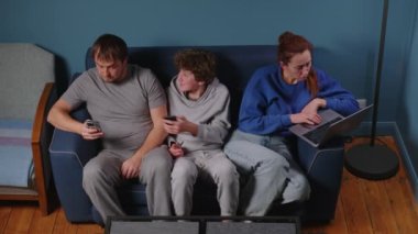 Aile birbirleriyle konuşmadan kanepede oturur. Cihazlara bağımlı, cep telefonu kullanan bir aile, evde birbirini görmezden gelen bir laptop. İnternet saplantısı. Yüksek kalite 4k görüntü