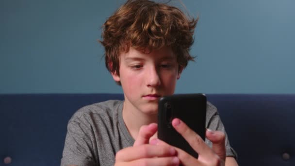 Dziecko Bawiące Się Telefonem Domu Leżące Kanapie Chłopak Gra Gry — Wideo stockowe