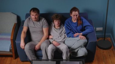 Fransız ailesi TV 'de maç izliyor, Fransa takımına tezahürat yapıyor, kollarını kaldırıyor, bağırıyor ve birbirlerine sarılıyorlar. Olimpiyat oyunları. Yüksek kalite 4k görüntü