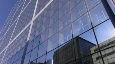Building reflected on glass skyscraper in Paris, grey skyscraper in Paris, open glass at left, blue sky and reflections. Wide Shot. High quality 4k footage