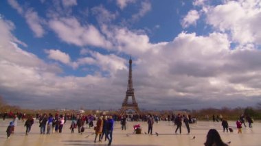 Paris, Fransa, 28 Mart 2022 İnsanlar Eyfel Kulesi 'nin yanında yürüyor. Arka planda güzel bulutlar hareket ediyor. Yüksek kalite 4k görüntü