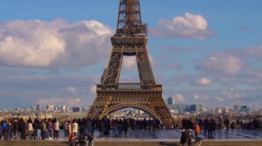 Paris, Fransa, 30 Mart 2023: Arabalar ve insanlar kule yakınında yol boyunca ilerliyorlar. Paris 'in en çok ziyaret edilen manzarası Eyfel Kulesi' dir. Yüksek kalite 4k görüntü