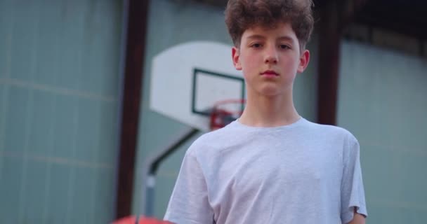 Видео Мальчика Стоящего Баскетбольной Площадке Держащего Баскетбольный Мяч Кинематографический Снимок — стоковое видео