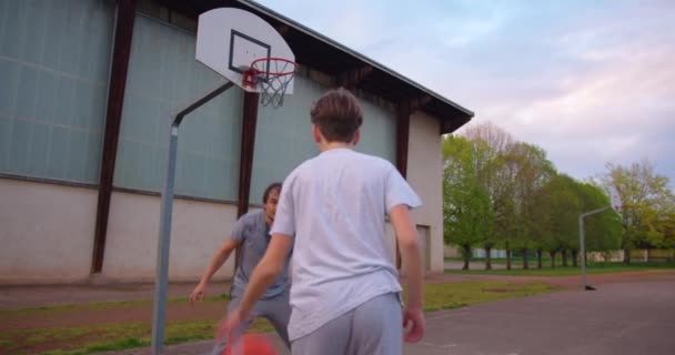 家族は一緒にスポーツをしたり 学校の近くのバスケットボールコートでバスケットボールをしたりして自由な時間を過ごしています 家族の健康 健康的なライフスタイルを強化する バスケットボールの練習 — ストック動画