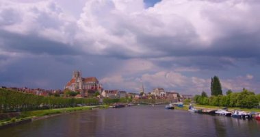 Atış süresi doluyor. Auxerre 'in merkezinde, arkasında bulutlar olan eski geleneksel Fransız evleri olan güzel cadde. Fransız tarihinin mirası. Fransa 'da renkli evler.