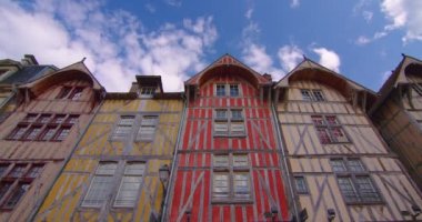 Troyes 'in merkezinde, arkasında bulutlar olan eski, geleneksel Fransız evlerinin olduğu güzel bir caddenin hızlandırılmış görüntüsü. Çekim başlıyor. Fransız tarihinin mirası. Fransa 'da renkli evler.