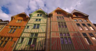 Troyes 'in merkezinde, arkasında bulutlar olan eski, geleneksel Fransız evlerinin olduğu güzel bir caddenin hızlandırılmış görüntüsü. Çekim başlıyor. Fransız tarihinin mirası. Fransa 'da renkli evler.