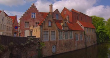 Çekim başlıyor. Bruges 'ün Belçika mimarisinin simgeleri. İnsanlar ve turistler yürüyor. Bruges Kulesi 'nin çan kulesi ve arka planda gotik binalar.