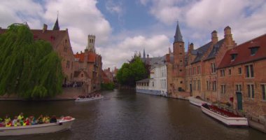 Brugge, Belçika, 25 Mayıs 2023, çekim başlıyor. Bruges 'ün Belçika mimarisinin simgeleri. İnsanlar ve turistler yürüyor. Bruges Kulesi 'nin çan kulesi ve arka planda gotik binalar.