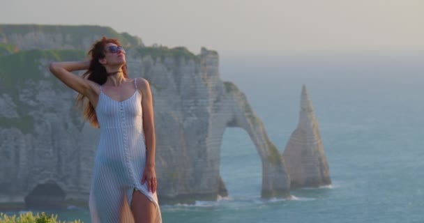 Eine Frau Mit Sonnenbrille Und Kleid Rande Einer Klippe Vor — Stockvideo
