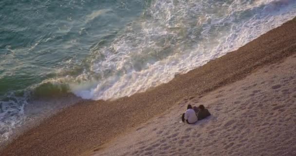 情侣们坐在大海里欣赏大海的巨浪 埃特雷塔特坐落在英吉利海峡的海岸上 以其风景如画的海岸悬崖而闻名 这些悬崖形成了无数的自然拱门 — 图库视频影像