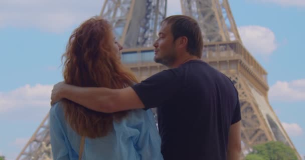 フランスの首都で休暇中の若い男性と女性は エッフェル塔周辺を歩き 活動をしています 幸せな美しいカップルで愛訪問パリ — ストック動画
