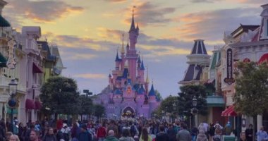 Fransa, Paris, 20 Haziran 2023: Disneyland 'deki pembe peri masalı şatosu. Paris 'teki Disneyland eğlence parkı kompleksi. Tema parkından sonra yürüyen kalabalık yılda yaklaşık 12 milyon ziyaretçi alıyor..