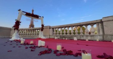 Paris 'teki Eyfel Kulesi' nin önündeki çiçekli kemer. Ateş eden adam Eyfel Kulesi 'nin yakınındaki sevgilisine sürpriz evlilik teklifi yapıyor..